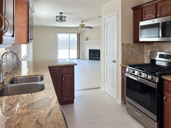a kitchen with granite countertop a sink stove and refrigerator