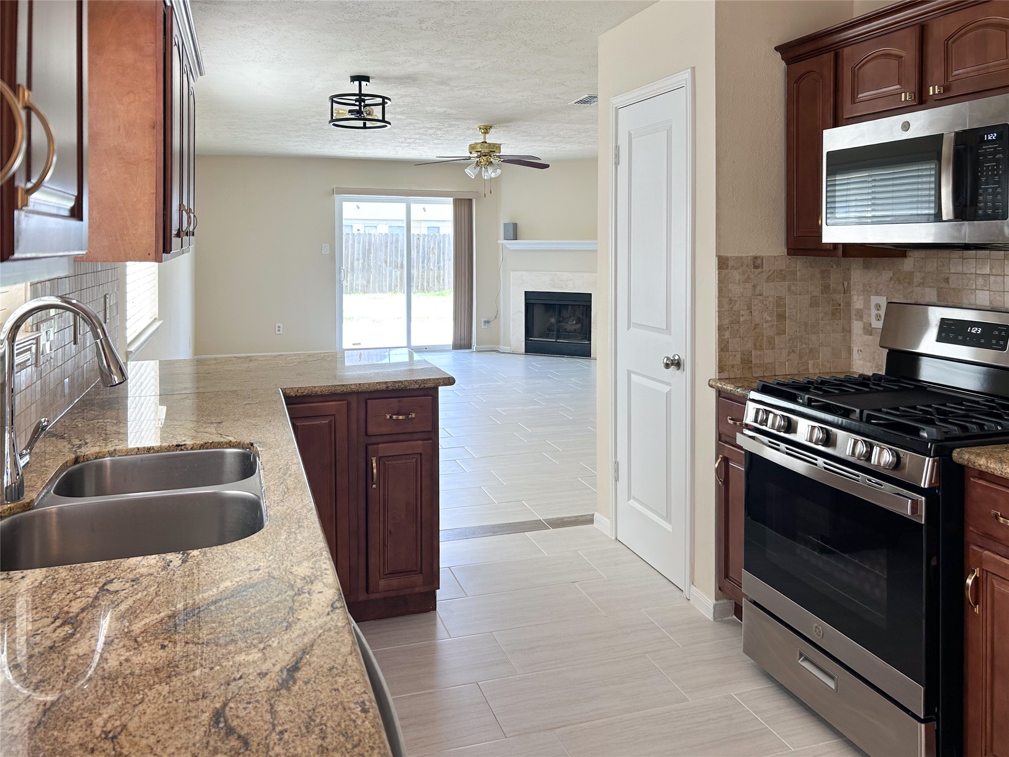 29219 Waltham Street Spring, TX 77386 - Photo 6 of 23 a kitchen with granite countertop a sink stove and refrigerator