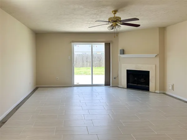 a view of an empty room with a fireplace and a window