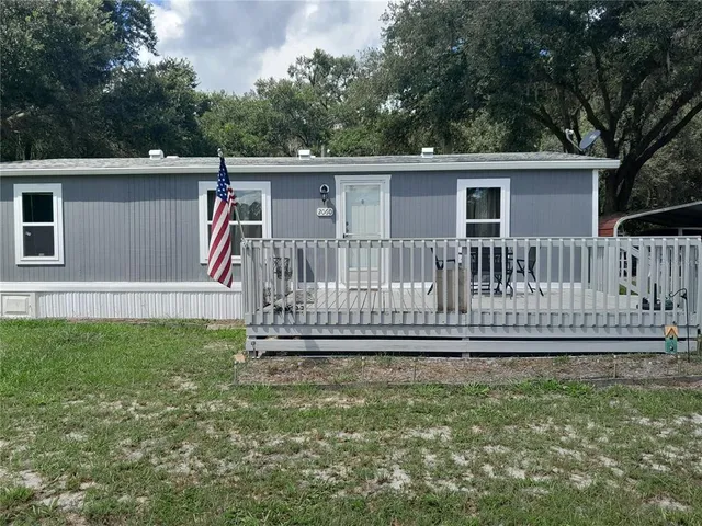 a view of a house with backyard and deck