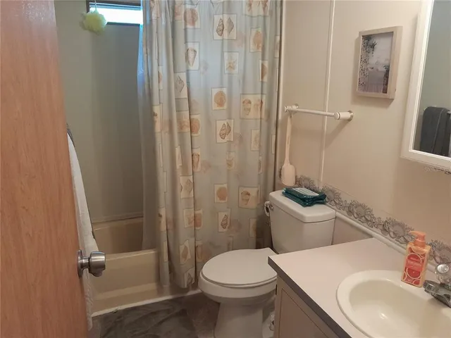 a bedroom with a bed and a flat tv screen on a dresser