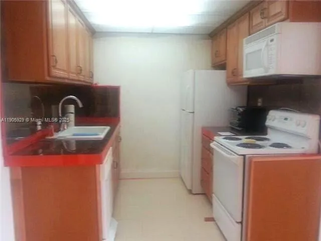 a kitchen with a refrigerator sink and cabinets