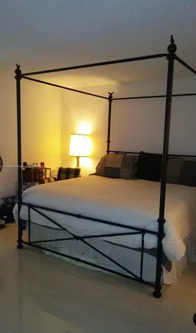 a bedroom with a bed and a night stand next to a window