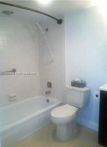a white toilet sitting next to a bath tub