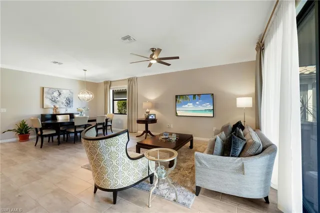 a living room with couches a computer and a window with wooden floor