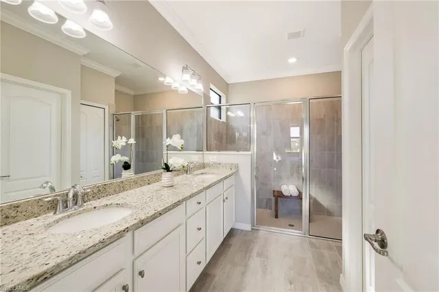 a bathroom with a granite countertop sink a mirror and a shower