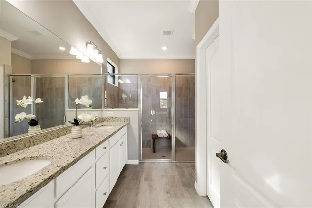 a bathroom with a granite countertop sink a mirror and shower