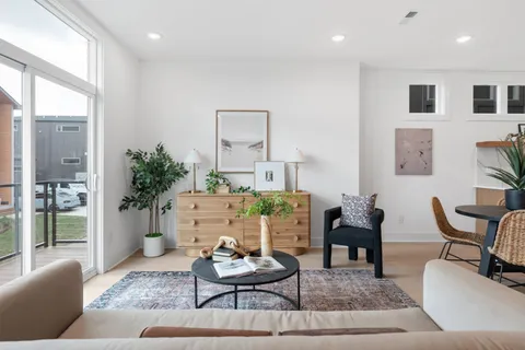 a kitchen with stainless steel appliances kitchen island granite countertop a refrigerator and a dining table