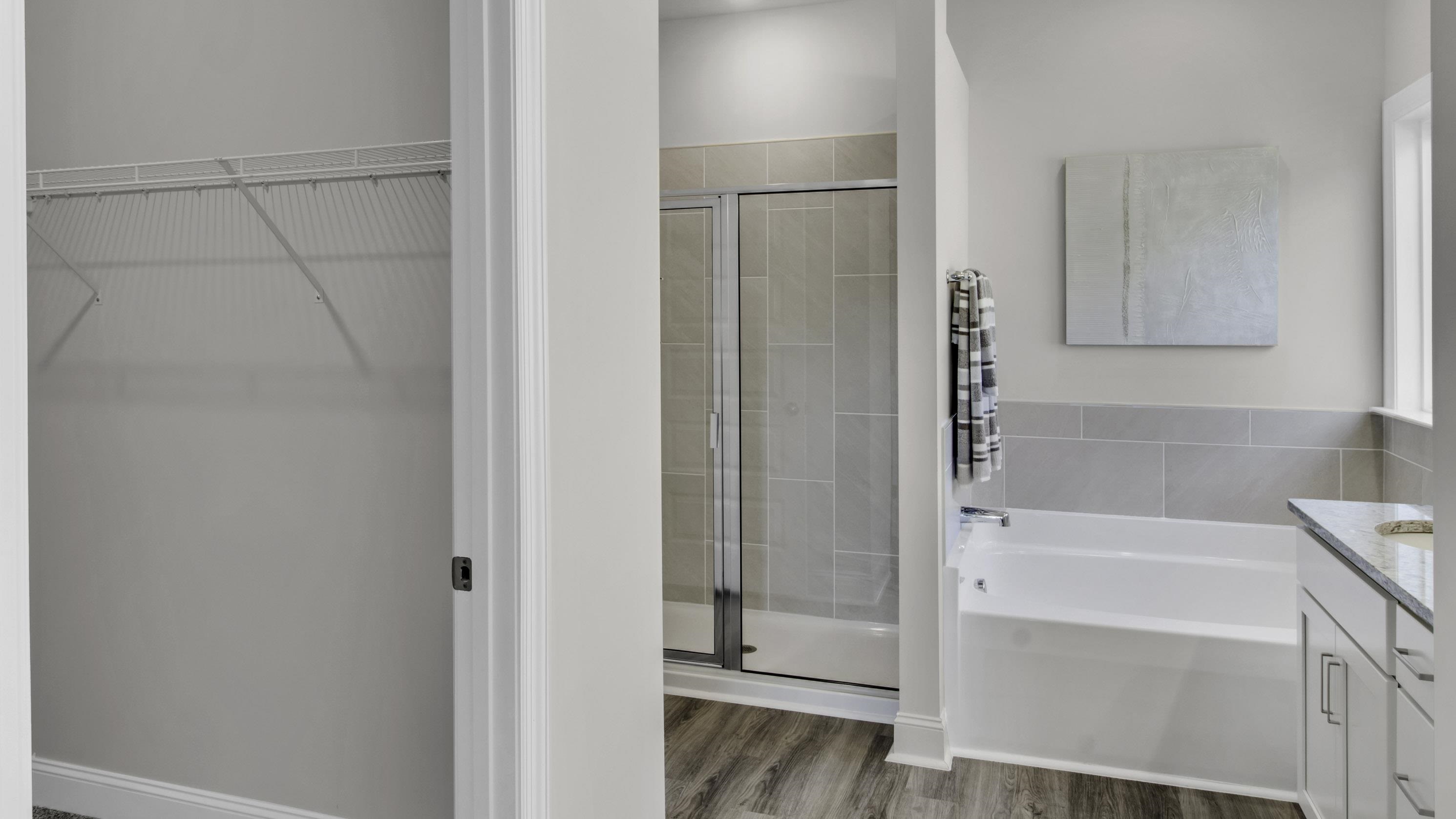990 Mewborn Farm Road Oakland, TN 38060 - Photo 18 of 40 Full bathroom featuring vanity, a bath, a stall shower, and dark wood-style flooring