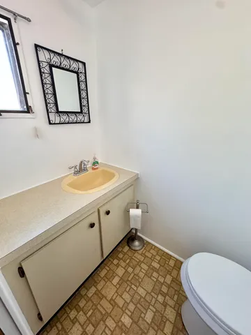 a bathroom with a sink toilet and mirror