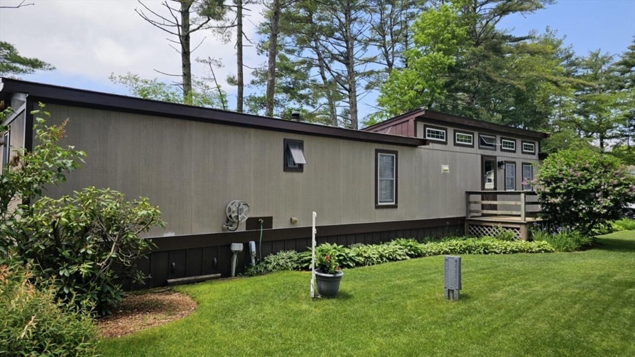 189 Pine View Terrace West Wareham, MA 02571 - Photo 2 of 22 a backyard of a house with potted plants and a large tree