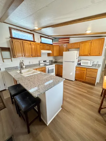 a kitchen with granite countertop a sink and a stove top oven
