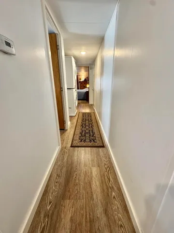 a view of a hallway with wooden floor