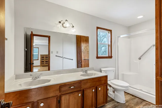 a bathroom with a granite countertop toilet a sink and a mirror