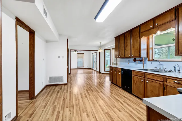 a large kitchen with wooden floors and wooden cabinets