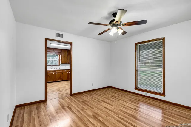 a view of empty room with wooden floor