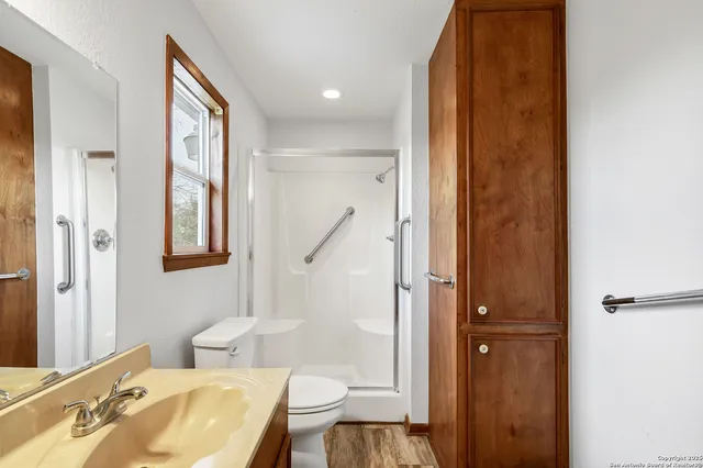 a bathroom with a granite countertop sink toilet and shower