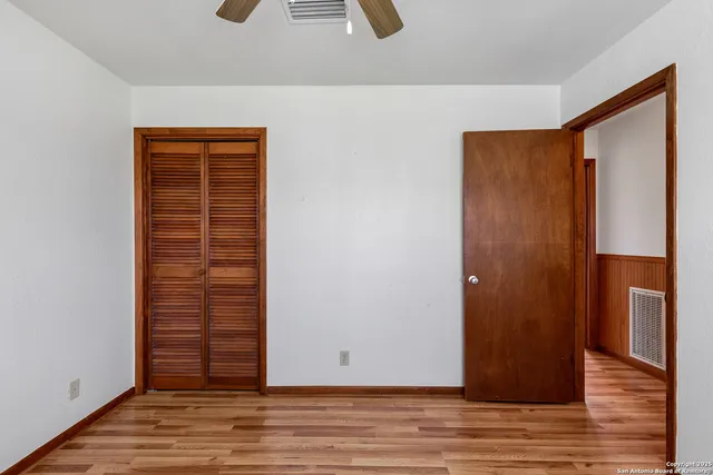 an empty room with wooden floor and closet