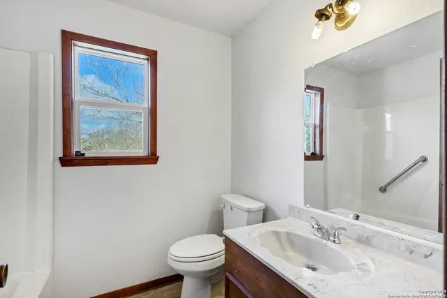 a bathroom with a toilet sink and mirror