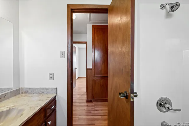 a bathroom with a granite countertop sink and a mirror