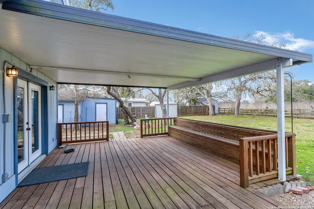 a view of a patio with a table chairs and wooden floor