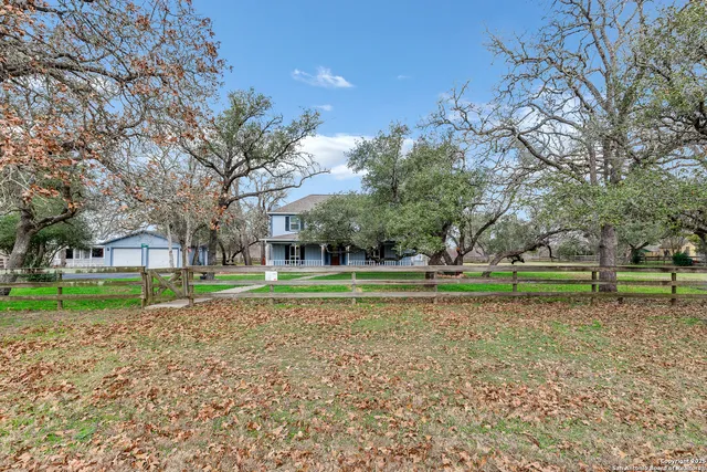 a backyard of a house with lots of green space and fountain
