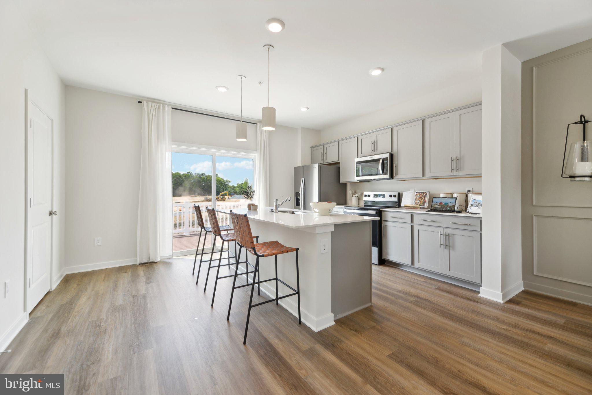 466 Still Feather Avenue La Plata, MD 20646 - Photo 24 of 89 a kitchen with a table chairs microwave and cabinets