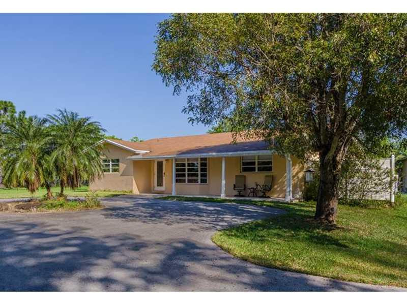 17201 Southwest 48th Street Southwest Ranches, FL 33331 - Photo 1 of 8 a front view of a house with a garden