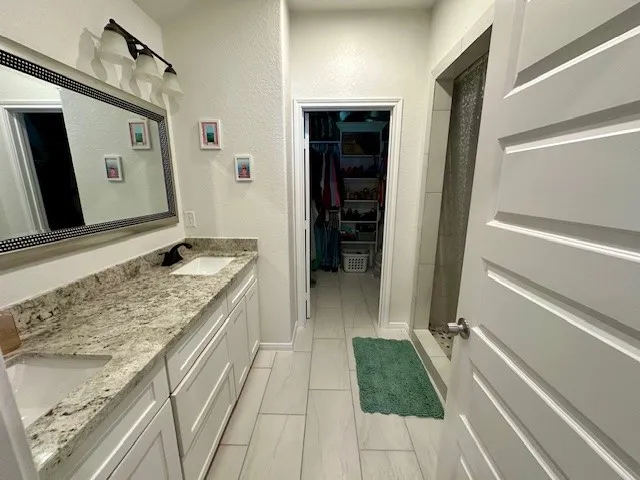 a bathroom with a granite countertop sink and a mirror