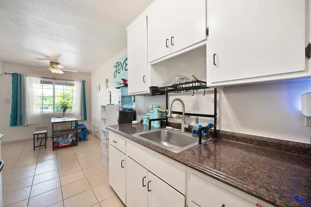 a kitchen with sink refrigerator and cabinets