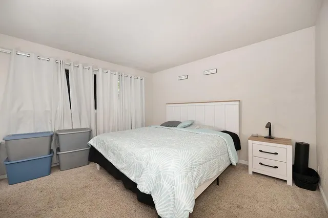 a living room with furniture a flat screen tv and a floor to ceiling window