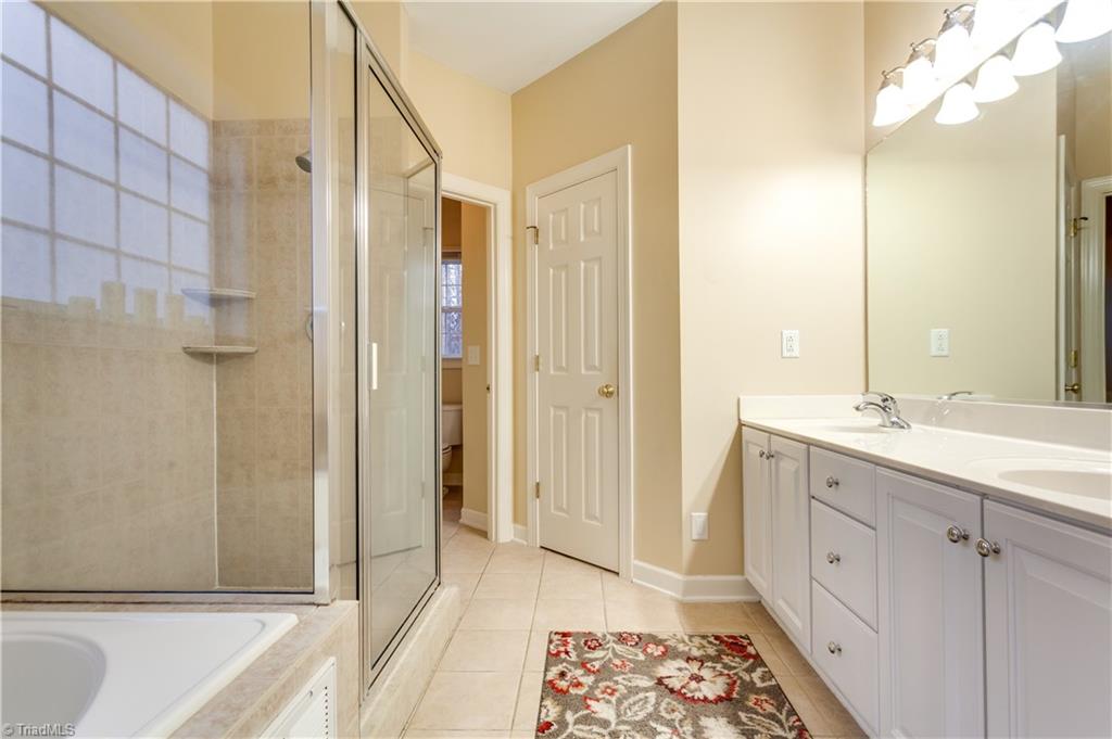 6599 Currieton Drive Oak Ridge, NC 27310 - Photo 14 of 30 The custom Master Bath features tile flooring, a double vanity sink with ample under sink storage and drawers, a soaking tub, a custom oversized walk in shower, a separate water closet and a Walk In Closet.