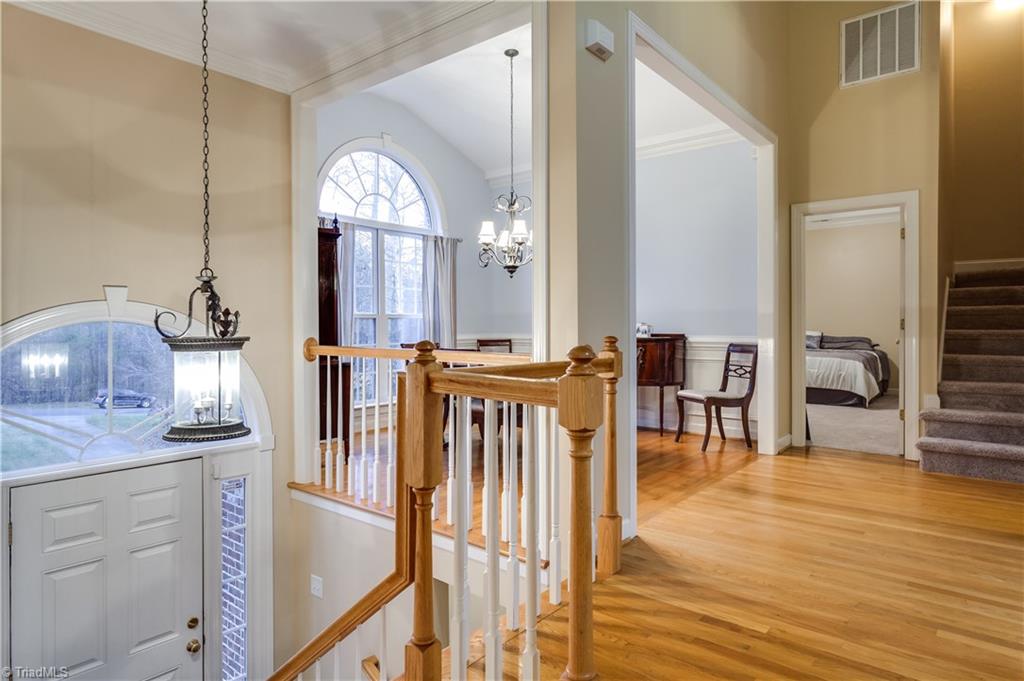 6599 Currieton Drive Oak Ridge, NC 27310 - Photo 3 of 30 The dramatic foyer offers vaulted ceilings, hardwood flooring, fresh neutral paint, palladium style windows and is flooded with natural light!