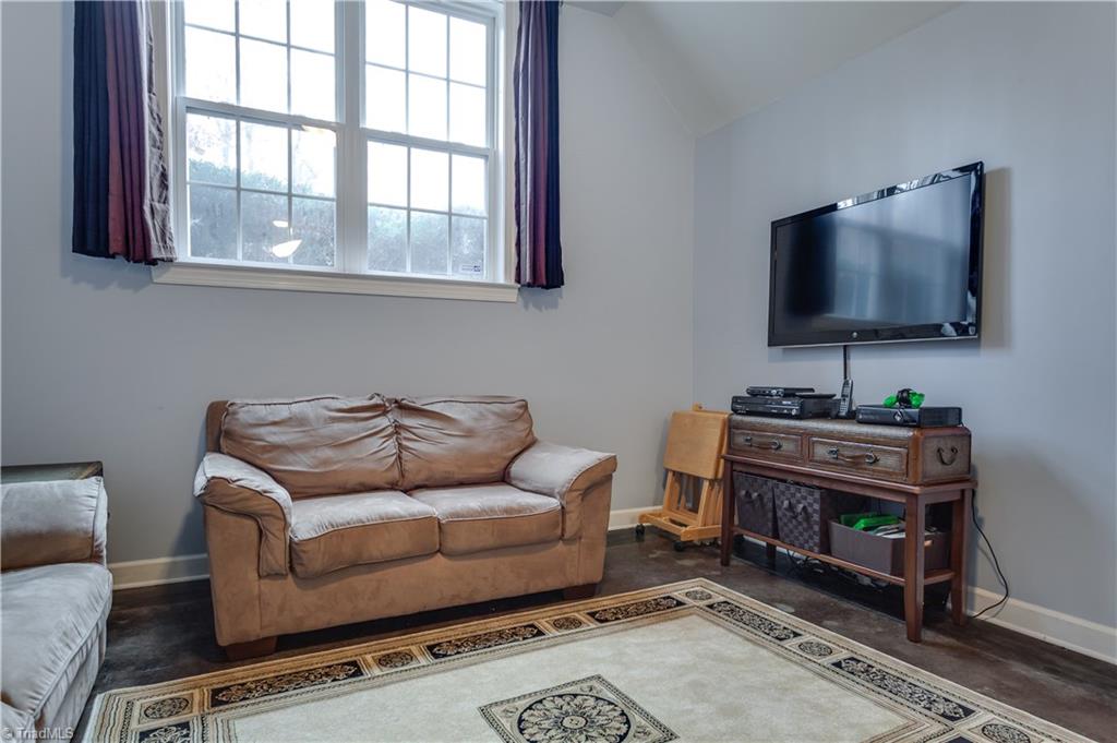 6599 Currieton Drive Oak Ridge, NC 27310 - Photo 20 of 30 The TV room in the basement features custom stained concrete floors!