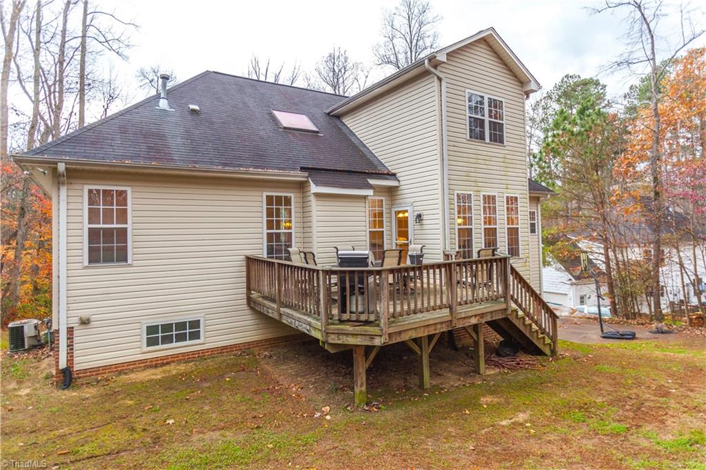 6599 Currieton Drive Oak Ridge, NC 27310 - Photo 26 of 30 The rear of the home shows off all three levels, skylights and deck!