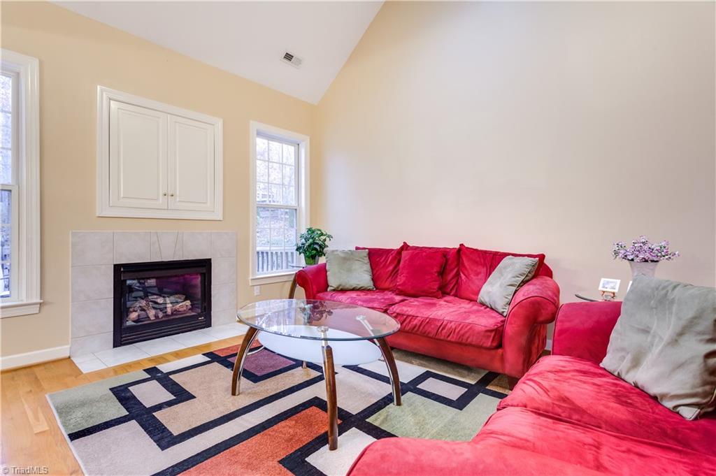 6599 Currieton Drive Oak Ridge, NC 27310 - Photo 5 of 30 The Great room features vaulted ceilings, a gas fireplace, a tv niche over the fireplace, flanked with double windows!