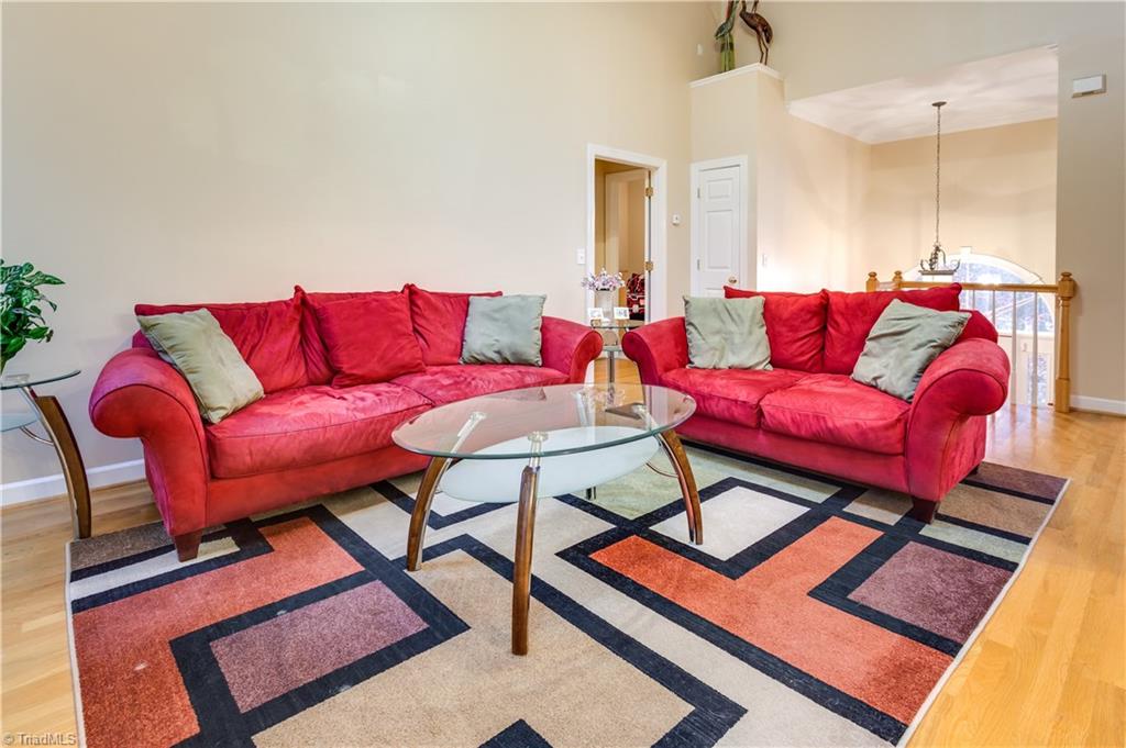 6599 Currieton Drive Oak Ridge, NC 27310 - Photo 6 of 30 The family room is open and features hardwood flooring.