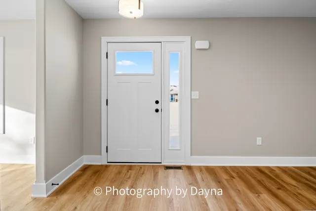 a large white kitchen with kitchen island a sink dishwasher a stove and a refrigerator with wooden floor