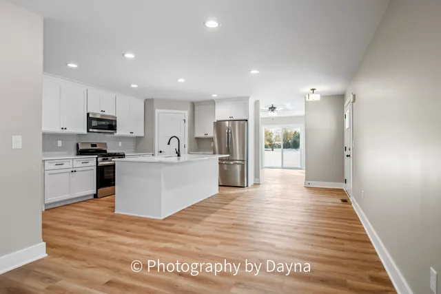 a kitchen with stainless steel appliances a sink dishwasher stove refrigerator and cabinets