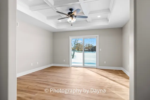 a view of empty room with window and ceiling fan