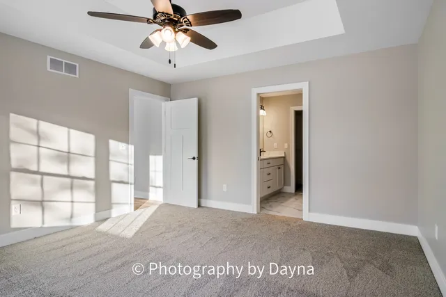 an empty room with a window and a ceiling fan