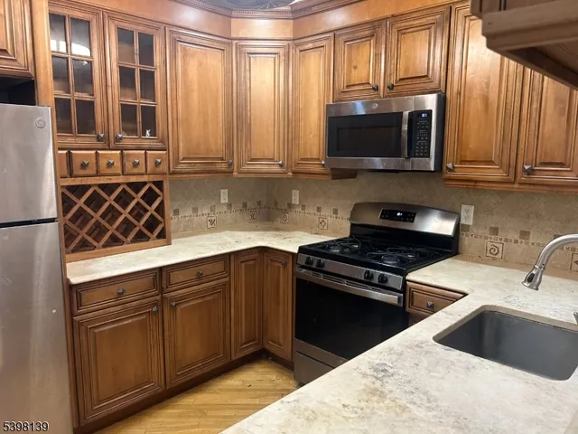 a kitchen with stainless steel appliances granite countertop a sink stove and microwave