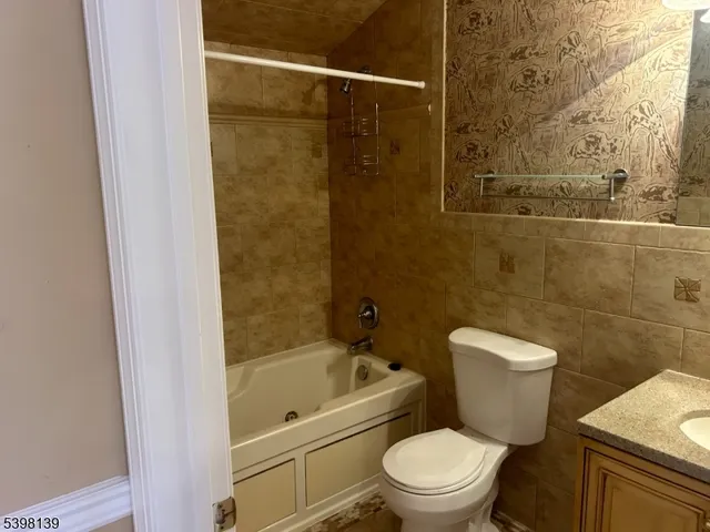 a white toilet sitting next to a bathtub