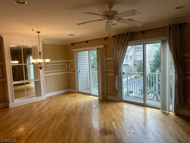 a view of a kitchen with wooden floor a ceiling fan and a kitchen