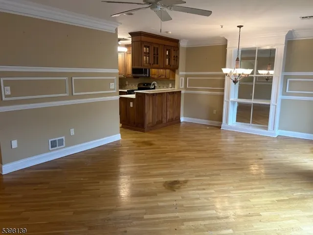 a kitchen with stainless steel appliances wooden floor and a refrigerator