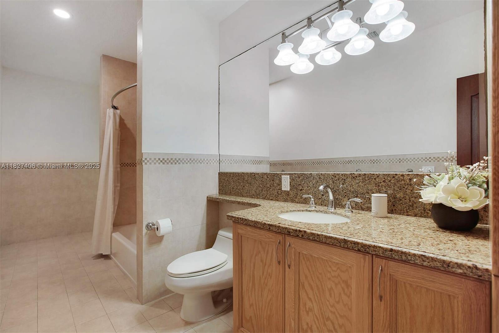 13550 Southwest 82nd Avenue Pinecrest, FL 33156 - Photo 18 of 25 a bathroom with a granite countertop toilet sink and mirror