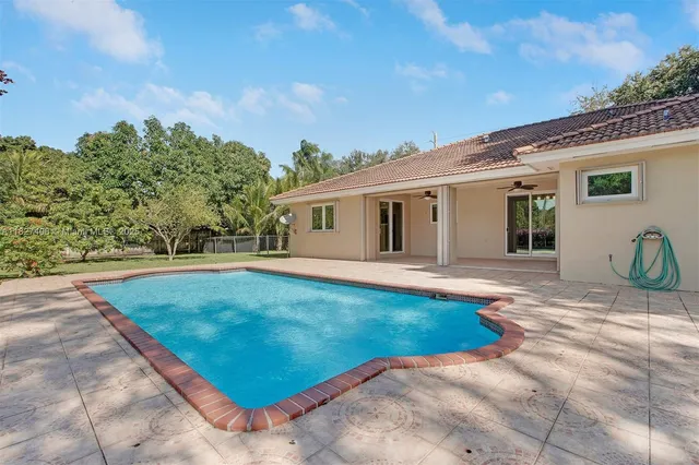 an aerial view of a house with a yard swimming pool and outdoor seating