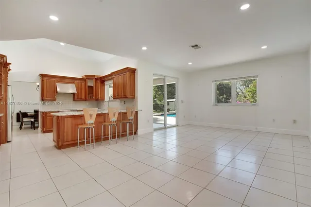 a kitchen with stainless steel appliances granite countertop a table and chairs in it