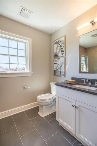 a bathroom with a toilet sink and mirror