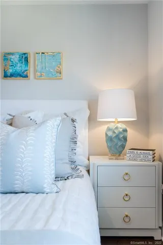 a bedroom with a bed and a painting on the wall